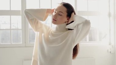 Beyaz arka planda tek başına duran sevimli kadın gülümsüyor. Güzel gözlü bir manken. Kameraya bakan muhteşem bir kızın portresi. Cilt bakımı, kozmetik ürünleri ve yaş karşıtı estetik cerrahi.