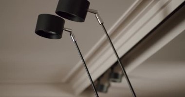 Minimalist iç dekordaki iki modern siyah masa lambasının yakın çekimi. Çağdaş dekor ya da çalışma alanı tasarımı için mükemmel. Modern Siyah Masa Lambaları Çağdaş Dekorasyon İçin Minimalist İçişleri