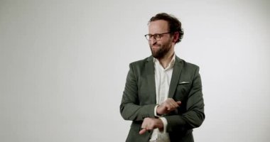 Takım elbiseli ve gözlüklü bir iş adamı beyaz bir arkaplanda komik ve garip dans hareketleri yapar. Elleriyle rahatsız edici yüz ifadeleri ve jestler yapıyor. Uygunsuzluk, mizah, kurumsal