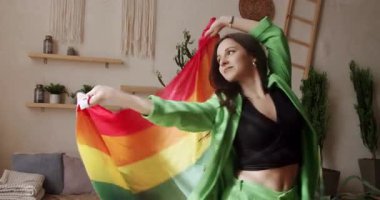 Mutlu lezbiyen kadınlar evde dinleniyor. İyi eğlenceler, LGBT bayrağıyla dans edin. Aşk LGBTQI, Gurur Etkinliği, LGBT Gurur Ayı, arkadaşlık konsepti. LGBT hakları, yaşam tarzı ve ilişkiler. LGBT kavramı.