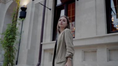 Şık bir şehir ortamını keşfeden zarif, genç bir kadın. Modern, kendine güvenen bir havayı somutlaştıran şık, sıradan bir kıyafet. Avrupa Sokaklarında Dolaşan Moda Genç Kadın