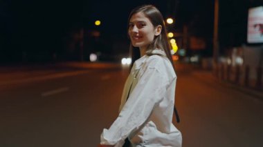 Genç bir kadın gecenin bir yarısı hareketli bir şehirde, sokak ışıklarının parıltısına dalmış bir yalnızlık anının tadını çıkarır. Gece Kentte Yanlız Yansıyan Genç Kadın