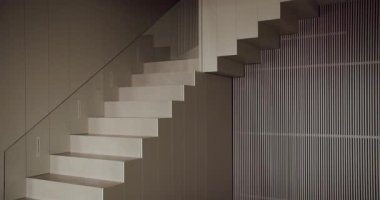 Bu görüntü modern, minimalist bir iç mekan, şık bir merdiven ve zarif çizgili bir duvar, çağdaş mimari sergiliyor. Modern İç Tasarım