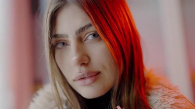 Gece şehirde neon ışıklarla yürürken genç ve çekici bir kadın kameraya bakıyor. Uzun, gevşek saçlı genç bir manken. Kameraya yakın çekim için kürk manto giymiş..