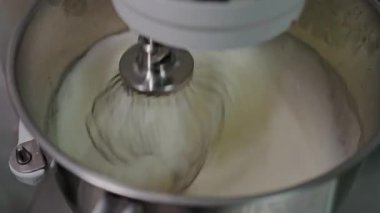 Mutfak mikser çırpma kremine yakından bakmak, profesyonel bir mutfak dokunuşuyla taze ev yapımı dondurma yapma sürecini yakalamak. Paslanmaz çelik karıştırma kasesinde taze krem çırpmak.