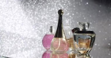 Parlak bir arka planda sergilenen lüks parfüm şişeleri koleksiyonu zarafet ve incelik sergiliyor. Güzellik, moda ve lüks kavramları için mükemmel. Güzel parfüm şişeleri