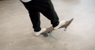 Genç bir insan kapalı alanda kaykay numaraları yapar. Tahtalarını ayaklarıyla çeviriyorlar. Video, kentsel gençlik kültürünün enerjisini ve tarzını yakalıyor. Kaykay için mükemmel.,