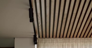 Ahşap tavanlı ve siyah ışıklı donanımlı modern iç tasarım. Şık ve minimalist ev dekorasyonu. Zarif ve sade bir yaşam alanı. Sıcak ve rahat bir atmosfer..