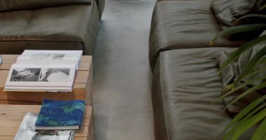 Deri kanepe ve ahşap masa ile süslenmiş Modern Kurul Dükkanı İçi Bitkiler ve Dergiler ile süslenmiş. Sörfçüler ve patenciler için rahat bir ortam.