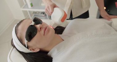 Yüz tazeleme, koruyucu gözlüklü güzel bir kadın estetik ilaçlar uygulanacak. Kadın güzellik kliniğinde LPG donanım masajı yaptırıyor. Güzellik tedavisi.