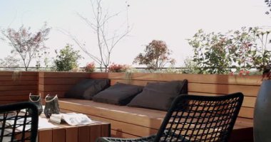 Ahşap mobilyaları ve yemyeşil bitkileri olan modern çatı bahçesi. Bu şehir vahasının sakin atmosferinin tadını çıkarın. Rahatlamak ve açık havada yaşamak için mükemmel..