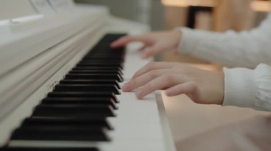 Genç kız evde piyano çalışıyor. Eğitim ve öğrenim geliştirme konsepti. Sessiz bir kişi dairesinde otururken piyano çalışır. Ev müziği stüdyosu kadını. müzik eğitimi.