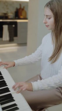 Genç kız evde piyano çalışıyor. Eğitim ve öğrenim geliştirme konsepti. Ev müziği stüdyosu kadını. Müzik eğitimi. Eller piyano tuşlarına basıyor. Nota okuyorum. Piyano öğrenme dersleri