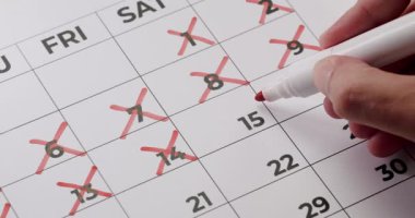 Takvimde günleri kırmızı kalemle işaretlemek. Planlama, planlama ve zaman yönetimi kavramı. Önemli tarihlerin vurgulanması ve izleme süreci.