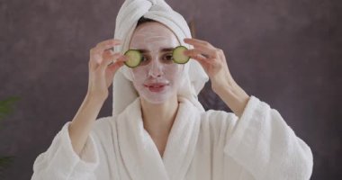 Cilt bakımı, nemlendirici ve nemlendirici konsept. Elinde organik sebze maskesiyle kameraya bakıp gülen tatlı bir genç kadın. Yaşlanma karşıtı. Sağlık, güzellik ürünleri ve cilt bakımı. Banyo yaptıktan sonra