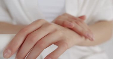 Kadın cildine krem sürüyor, yakın çekim. Beyaz krem cilt hastalığına iyi gelir. Fırçalama. Genç bir kadın günlük güzellik vücut prosedürü ya da tedavi uyguluyor. Hijyen ve cilt bakımı kavramı.