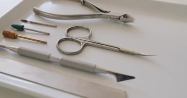 Çivi bakım aletleri. Profesyonel aletler, tırnak törpüsü, makas, meme uçları ve manikür için kuaför. Tırnak bakımı prosedürü için tepside steril aletler.