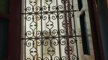 Karmaşık Fas tasarımıyla süslü metal bir kapı. Güneş ışığı avludan akıyor. Kuzey Afrika 'da mimarlık, kültür ve seyahat. Geleneksel Fas evlerinin güzelliği ve zanaatı