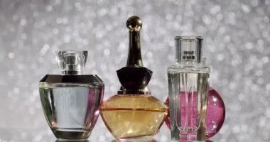 Işıldayan bir bokeh arka planına karşı çeşitli parfüm şişelerinin zarif gösterisi, lüksü, parfümü ve güzelliği ön plana çıkarıyor. Bokeh Güzellik Arkaplanlı Zarif Parfüm Şişeleri