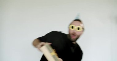 Parti şapkası ve komik gözlükleri olan heyecanlı adam bir doğum günü hediyesi alır, sevinçle kutlar ve havaya fırlatır. Eğlence, sürpriz ve şenlik havası. Doğum günü kutlamaları için mükemmel..