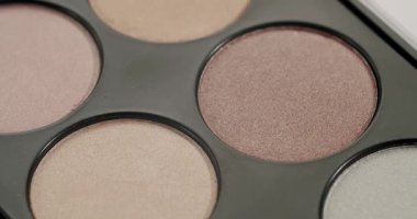 Renkli makyaj paleti. Kalem, bronzlaştırıcı ve allık tonlarıyla yavaşça dönüyor. Cazibe, dış görünüş ve günlük yüz makyajı için profesyonel güzellik ürünü.