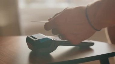 Bir mağazanın içinde POS terminali kullanarak ödeme yapan müşterilerin yakın çekimleri modern elektronik ve ticari bağlantısız işlemlerin kolaylığını gösteriyor.