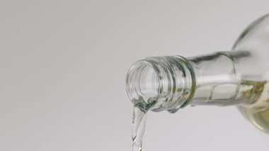 Şeffaf bir sıvının yavaş çekim yakın çekimi. Aşırı derecede temiz bir sıvıya yakın, muhtemelen su ya da votka, beyaz şarap gibi bir ruh süper yavaş çekimde beyaz bir arka planda izole edilmiş.