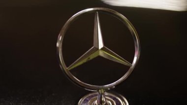 Chisinau Moldova 12.12.2026. Krom renkli bir Mercedes-Benz 'in yakın çekimi. Üç köşeli yıldız amblemi birinci sınıf bir arabanın koyu kaputuna yansıyor. Alman mühendisliğinin ve zenginliğinin sembolik sembolünü sergiliyor.,
