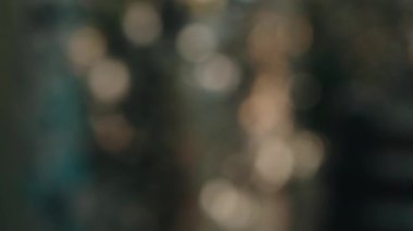 Güneşin parlaması ve güneş ışığı bir ağacın yeşil yapraklarından süzülüyor, şaşırtıcı soyut bir bokeh etkisi yaratıyor arka planlar, örtüler veya sinematik geçişler için mükemmel.