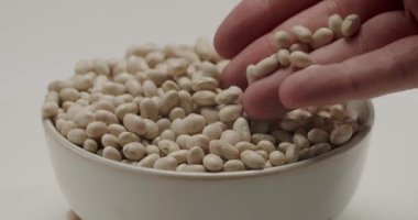 Bir adamın elinin yavaş çekimde seramik kaseden bir avuç beyaz kannellini fasulyesi alıp kalitelerini ölçtüğü ve sonra geri düşmelerine izin verdiği sahneler. Hepsi temiz beyaz bir arka planda.