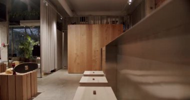 Minimalist tasarımı olan modern kurul iç mimarisi. Ahşap tezgah, tabure ve kaykay gösterimi modaya uygun bir atmosfer yaratıyor. Bitkiler ve hafif ışıklandırma uzaya biraz sıcaklık katar.