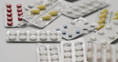 İzole edilmiş beyaz bir yüzeye serpilmiş gümüş su toplayan kapsüller, çok renkli ilaç hapları ve kapsüller beyaz bir zemin üzerinde duran su toplayan kapsüller.