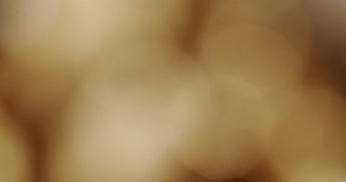 Soyut, yumuşak-odaklı arka plan, parlak altın renkli ışıklar, sıcak ve zarif bir atmosfer yaratıyor, örtüşmeler, tatiller ve kutlamalar için mükemmel