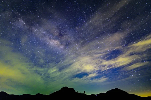 Nuvola inferiore e via lattea oltre la montagna Fotografia Stock