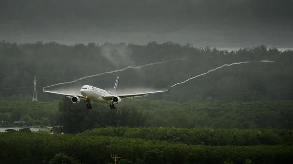 Thai airways letadlo přistání na letiště v Phuketu na mokré dráze s křídel vortice kondenzace — Stock fotografie