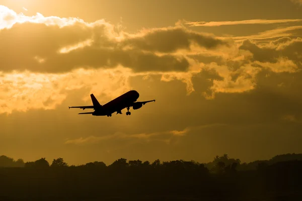 Silueta letadlo vzlétnout v ranní — Stock fotografie