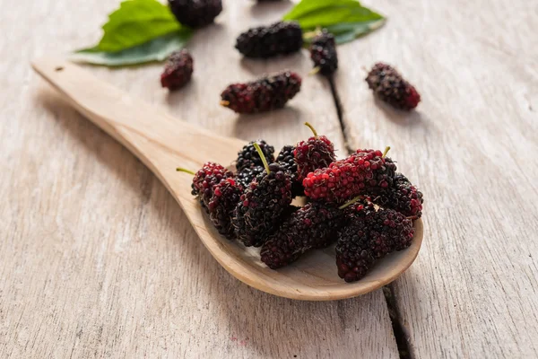 Framboise sur cuillère en bois sur plancher de bois — Photo