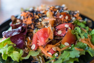 Tahıl siyah susam salata siyah çanak üzerinde