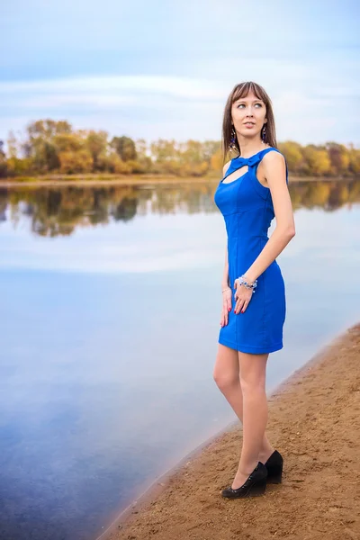 A slender girl in a blue dress on blurred background Royalty Free Stock Photos