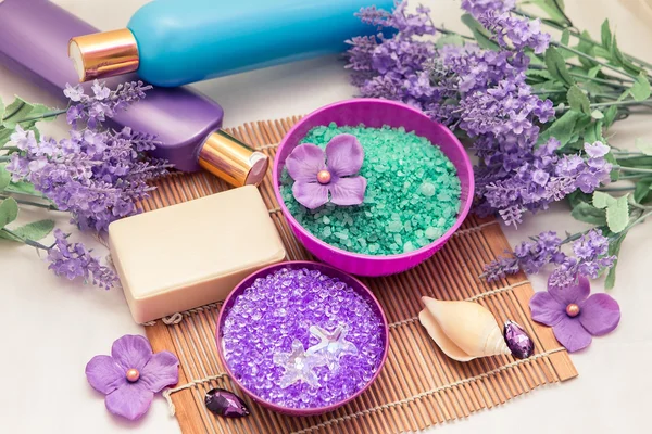 Интерьер ванной комнаты с морской солью, бутылками и мылом. Лаванда и фиолетовые средства гигиены цвета и аксессуары . Лицензионные Стоковые Изображения