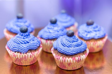 Böğürtlenli kek bir stand. Party dekorasyon gıda. Çilek ve krema ile cupcakes. Mor renk pastaları.