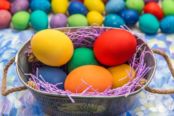 Huevos de Pascua coloridos sobre fondo brillante. Vacaciones de Pascua. Fondo multicolor de color verde, azul y púrpura. Huevos de Pascua en una cesta . — Foto de Stock