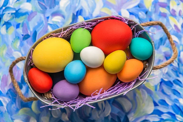 Colorful Easter eggs on bright background. Easter holiday. Multicolored background green, blue and purple colors. Easter eggs in a basket. — Stock Photo, Image