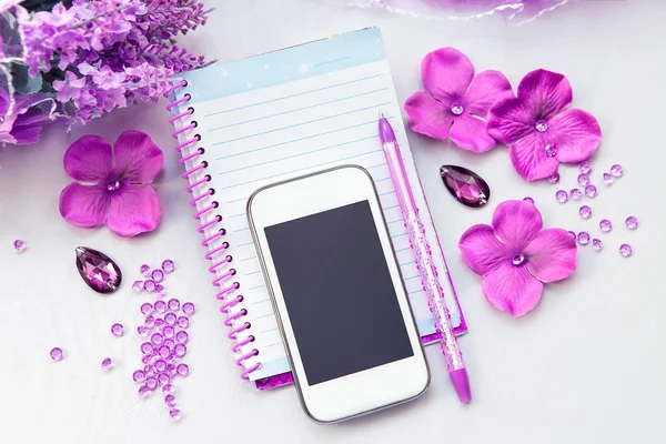 Oficina de suministros de mujeres de negocios. Teléfono, cuaderno y bolígrafo. Algunas cosas de oficina sobre un fondo blanco. Accesorios en la mesa. Color rosa púrpura detalles interiores . — Foto de Stock