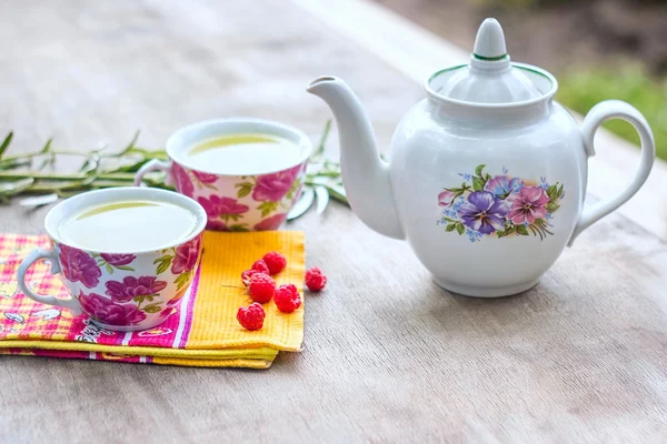 Hermosas tazas de té y bayas sobre fondo de madera —  Fotos de Stock