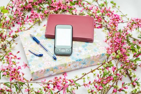 Accesorios de oficina con hermosas ramas de flores carmesí sobre un fondo blanco — Foto de Stock