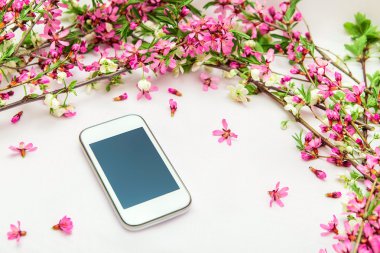Süslemeleri çiçekleri dalları ile bir cep telefonu