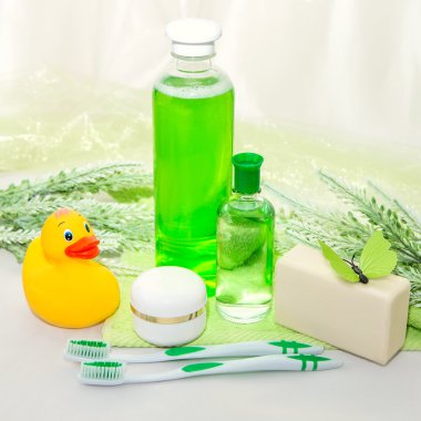 Yeşil bir havlu üzerinde banyo aksesuarları