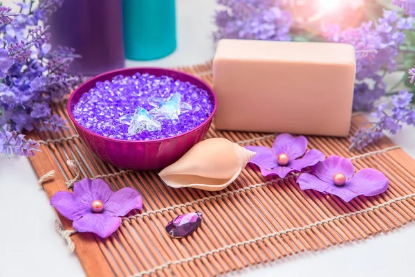 Украшения ванной комнаты с морской солью, бутылками и мылом. Лаванда и фиолетовые средства гигиены цвета и аксессуары. Морская соль и кристаллы . Лицензионные Стоковые Изображения