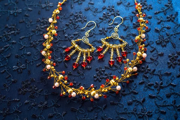 Bellissimi ornamenti d'oro per i capelli su uno sfondo scuro. gioielli in oro per le donne. collana e orecchini — Foto Stock